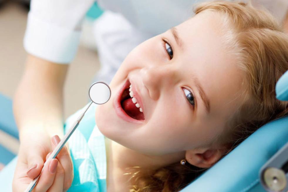 A young girls smiling during a dental checkup