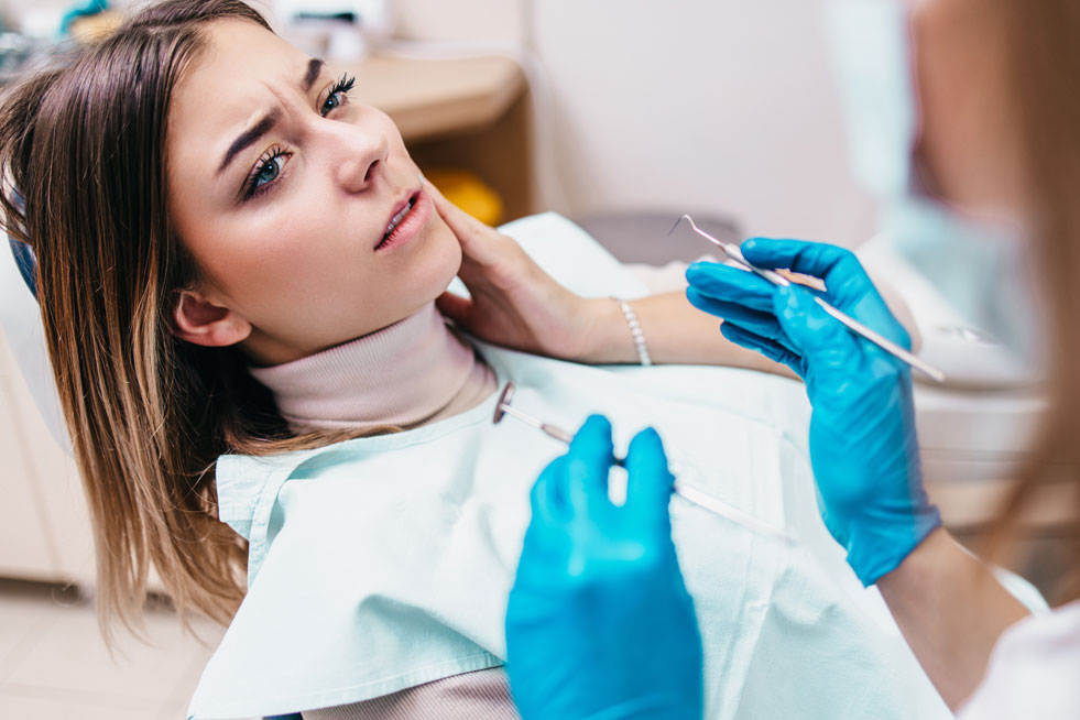 Women with a sore mouth sitting in a dental chair